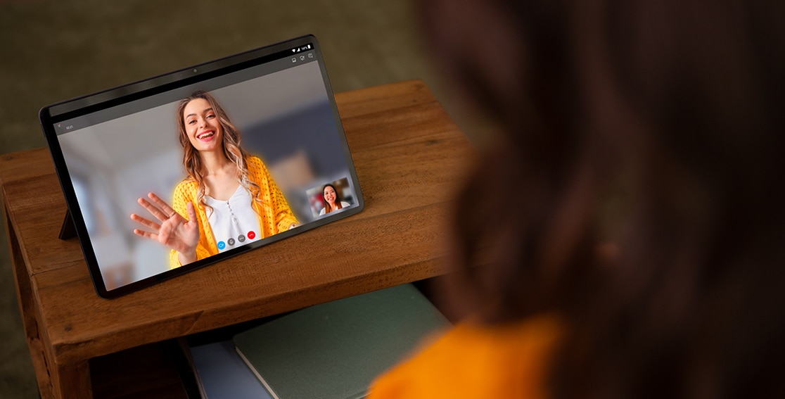 ¾ front view of two hands holding Lenovo Tab P11 tablet horizontally during video call